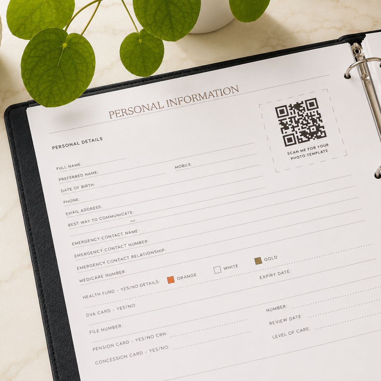 My Medical Folder open to the Personal Information section, showing personal details, emergency contact information and a photo template QR code on a marble surface with green leaves.