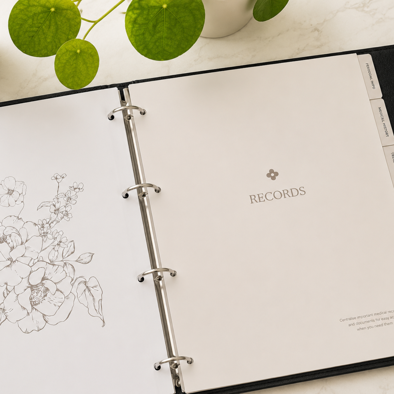 My Medical Folder open to the Records section, showing a floral page design and organised medical record pages on a light marble surface